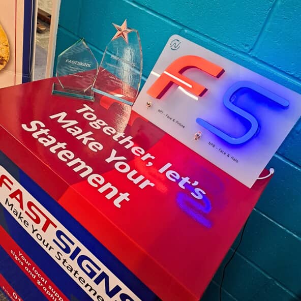 An image of the FASTSIGNS convention table with both awards in the corner.